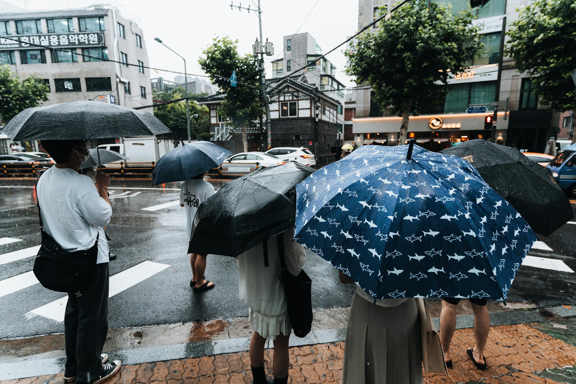 Rainy Jakarta street with traffic and umbrellas