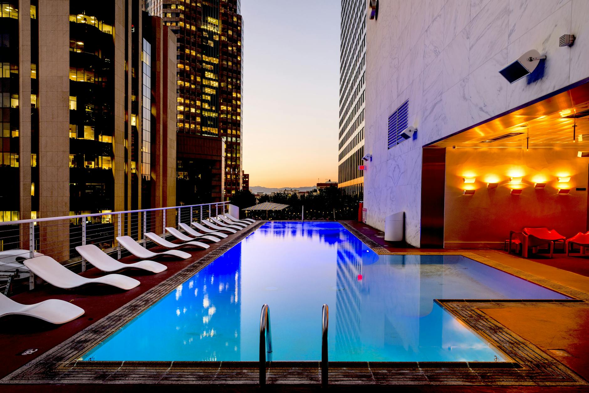 Luxury rooftop pool with city skyline view at sunset