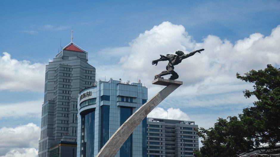 Clear blue sky over the Selamat Datang monument and Jakarta skyline during dry season