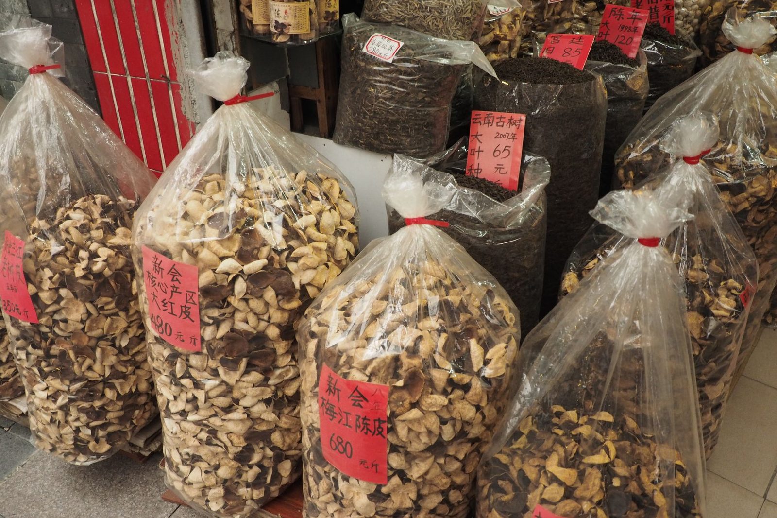 Labelled bags of dried Chinese herbs at a traditional medicine stall in the Glodok market lanes