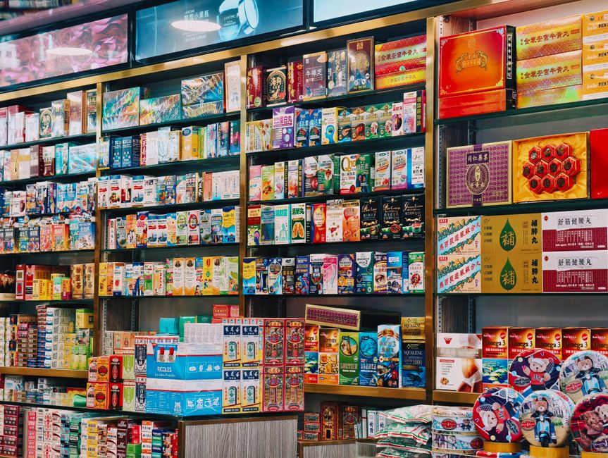 Shelves stocked with boxes of over-the-counter medicine in a pharmacy, similar to Jakarta's apotek chains