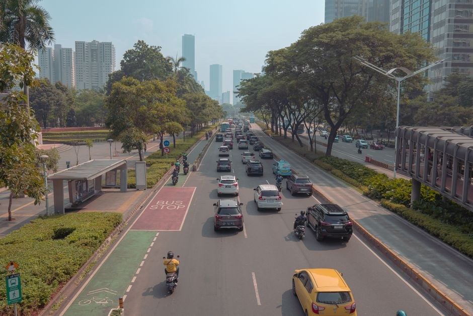 Multi-lane road busy with cars and motorbikes in central Jakarta during the day