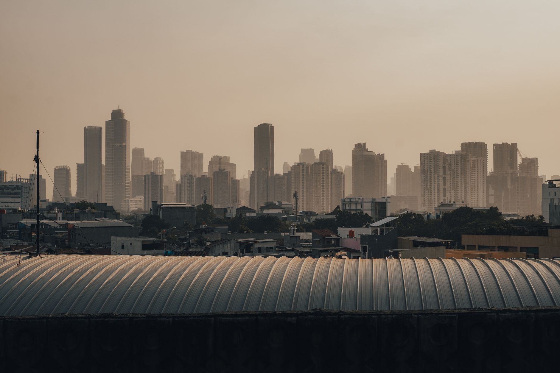 Jakarta skyline shrouded in dry-season haze at dusk, illustrating typical air quality conditions