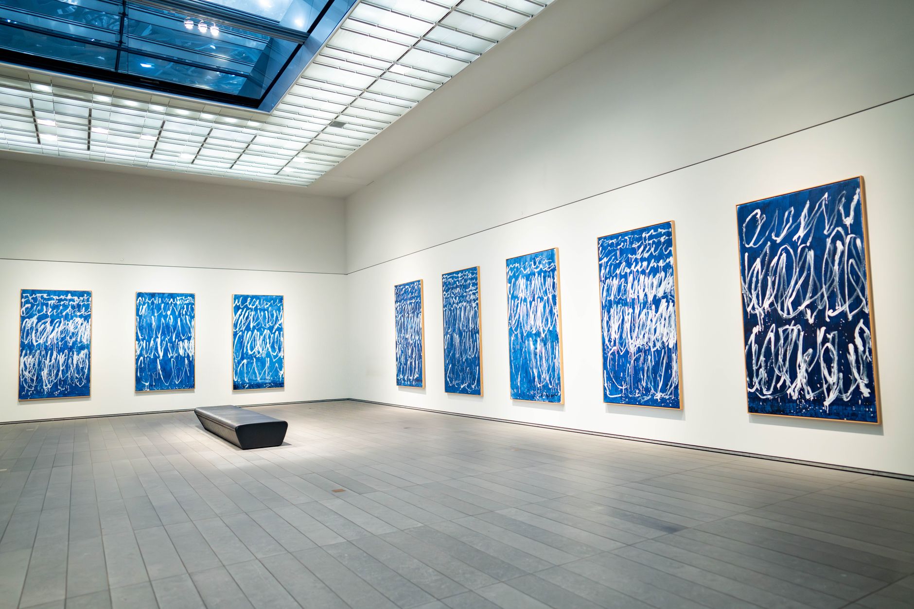 Paintings hung on white walls in a contemporary art gallery of the kind found across Kemang