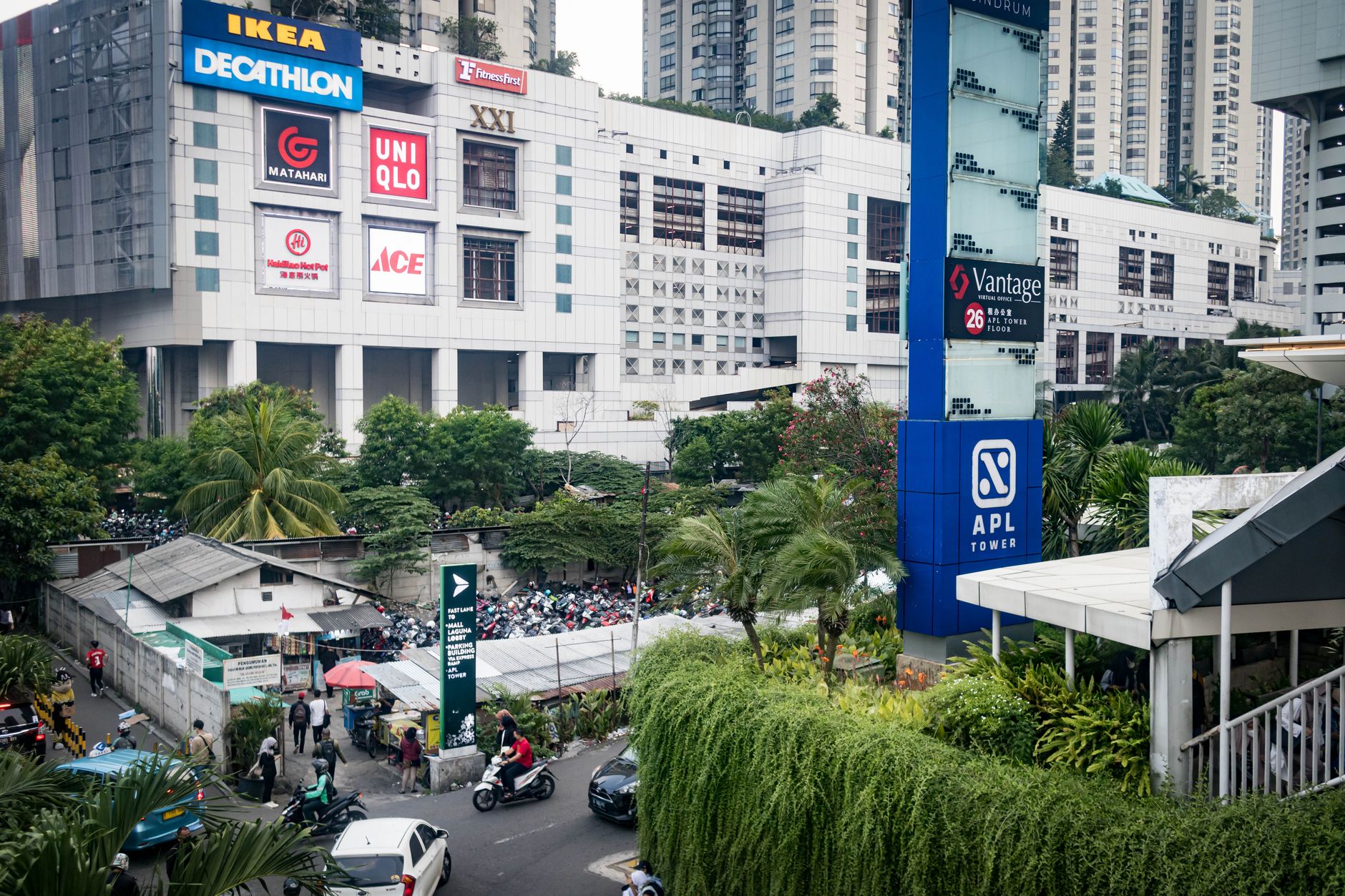 Aerial view of a low-rise South Jakarta retail street with trees and parked motorbikes, typical of the Kemang neighborhood Jakarta layout