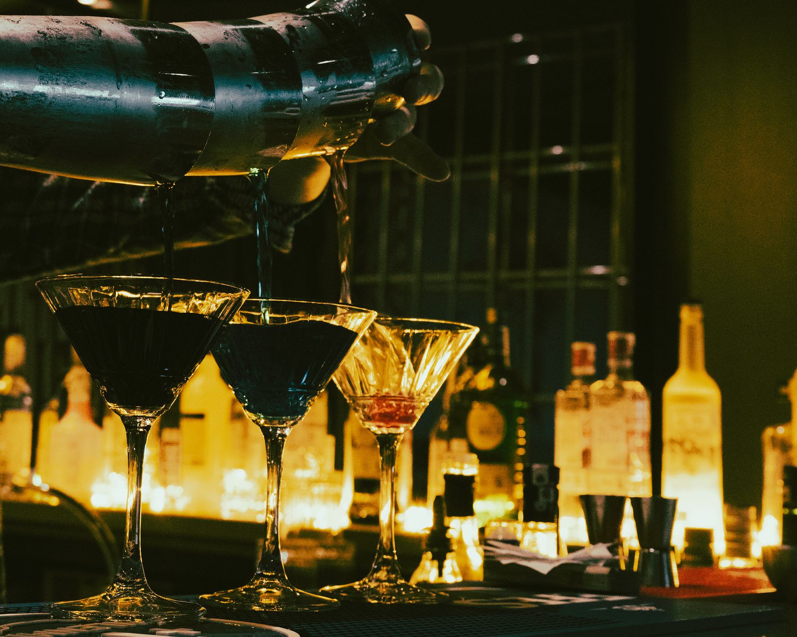 Bartender pouring cocktails at a dimly lit bar in Kemang Jakarta