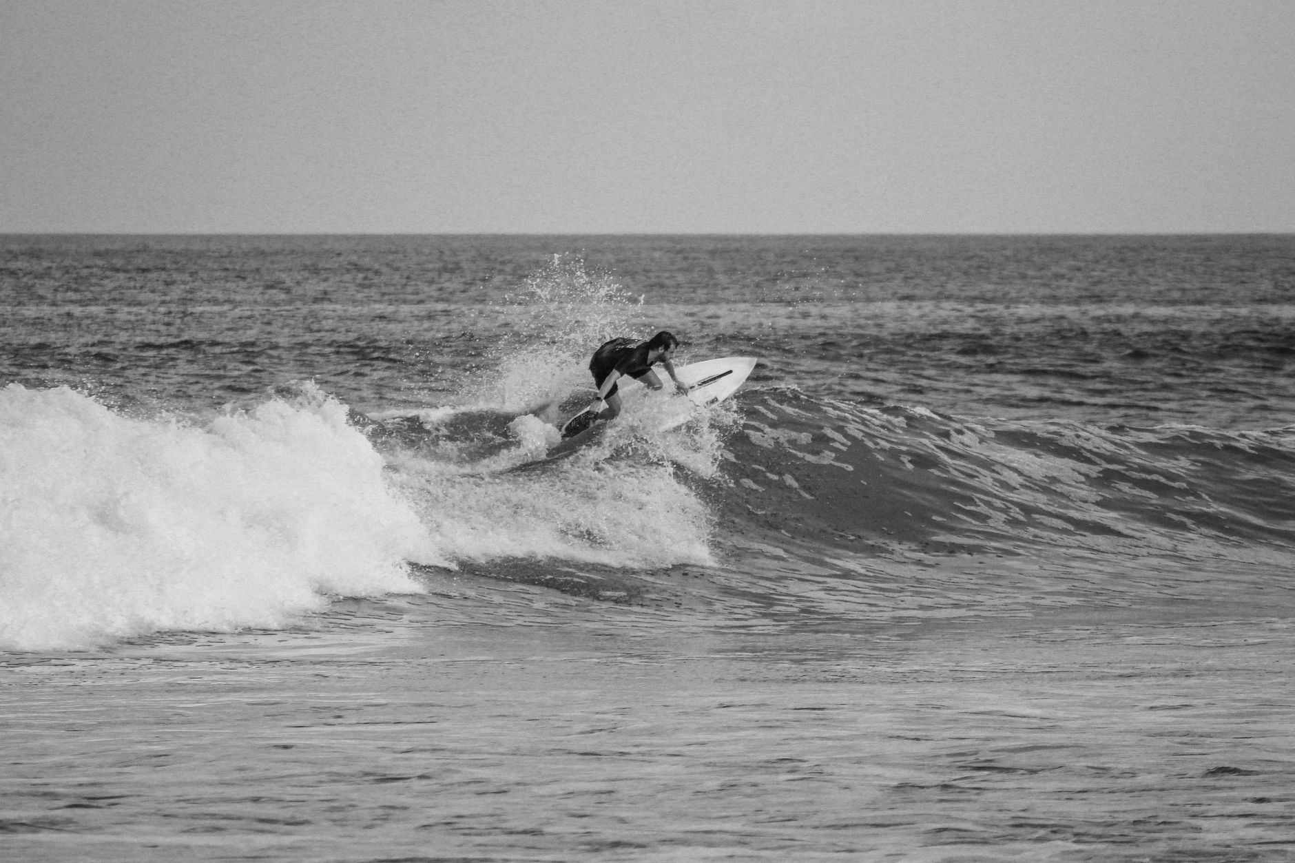 A surfer riding the face of a wave on an Indonesian beach break, the draw of Pelabuhan Ratu near Jakarta