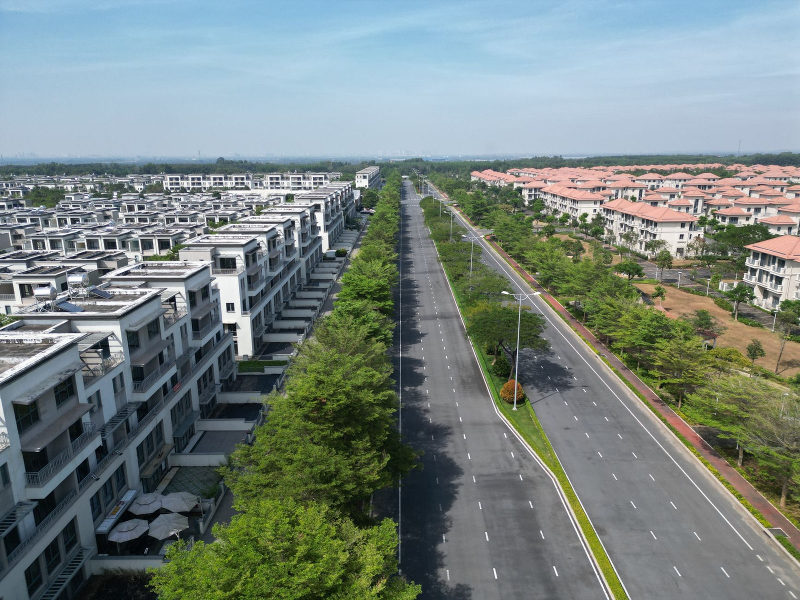 A wide landscaped avenue lined with modern low-rise housing in a planned Jakarta suburb, as in this Pondok Indah Jakarta guide