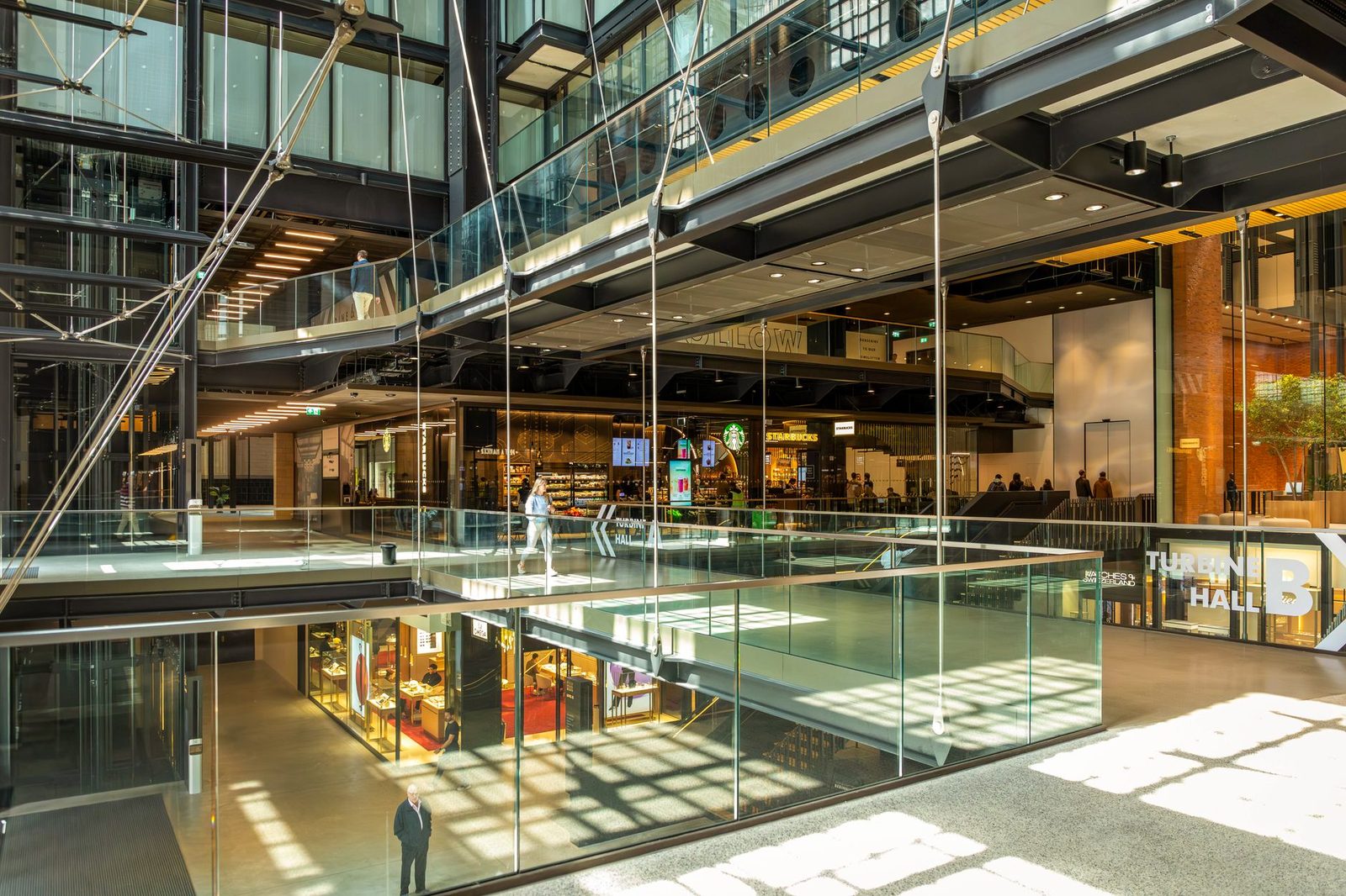 Glass balconies and escalators inside a modern shopping mall of the kind at Pondok Indah Mall