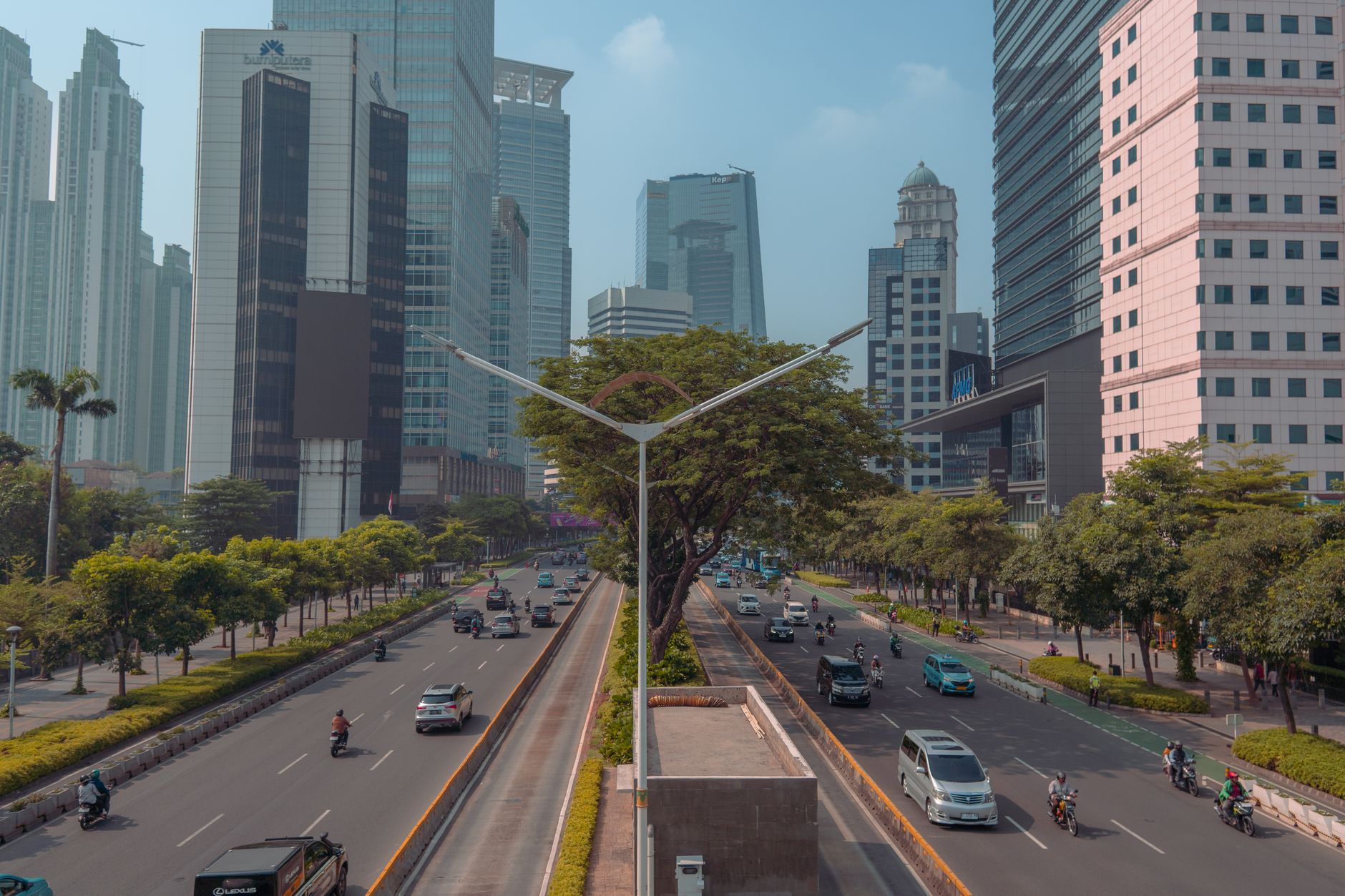 A wide tree-lined avenue flanked by glass office towers on Jalan Sudirman, the spine of this SCBD Sudirman guide Jakarta