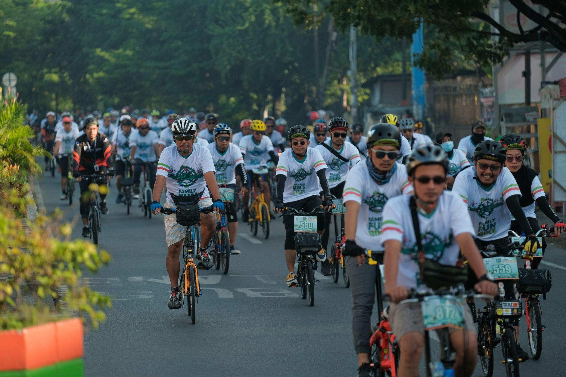 A dense pack of cyclists riding down a closed city road during Jakarta Car Free Day near Senayan