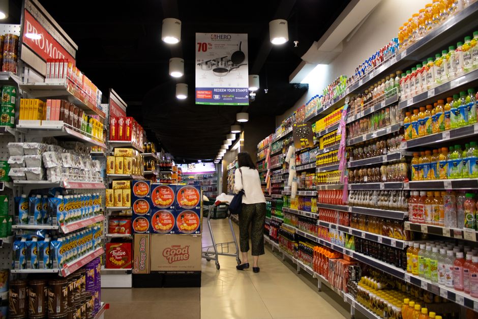 Interior of an Indonesian convenience store aisle, the kind of minimarket where starter SIM cards are sold near the till
