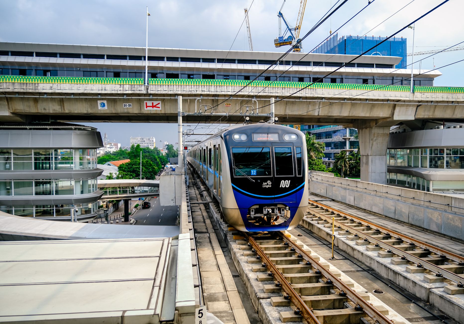 A Jakarta MRT train crossing an elevated viaduct above a South Jakarta street, the spine of any South Jakarta guide